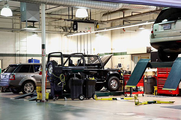 Palm Springs,United States - November 16,2011: Pristine clean interior of Automotive Garage servicing three late model SUV's. One Vehicle on a hoist . Two vehicles on floor. No people in image.